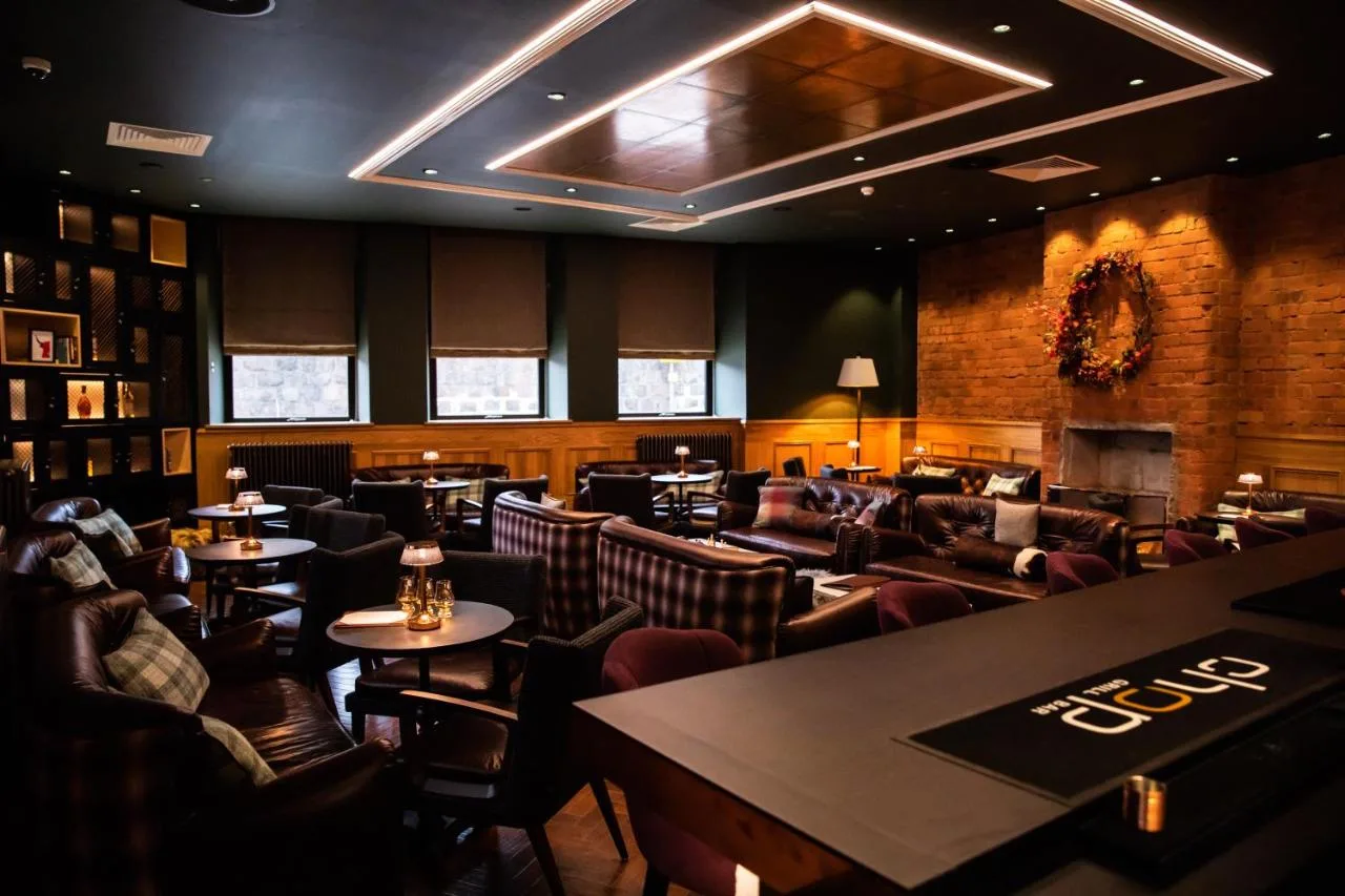 a restaurant with couches and tables and chairs at Sandman Signature Aberdeen Hotel & Spa in Aberdeen