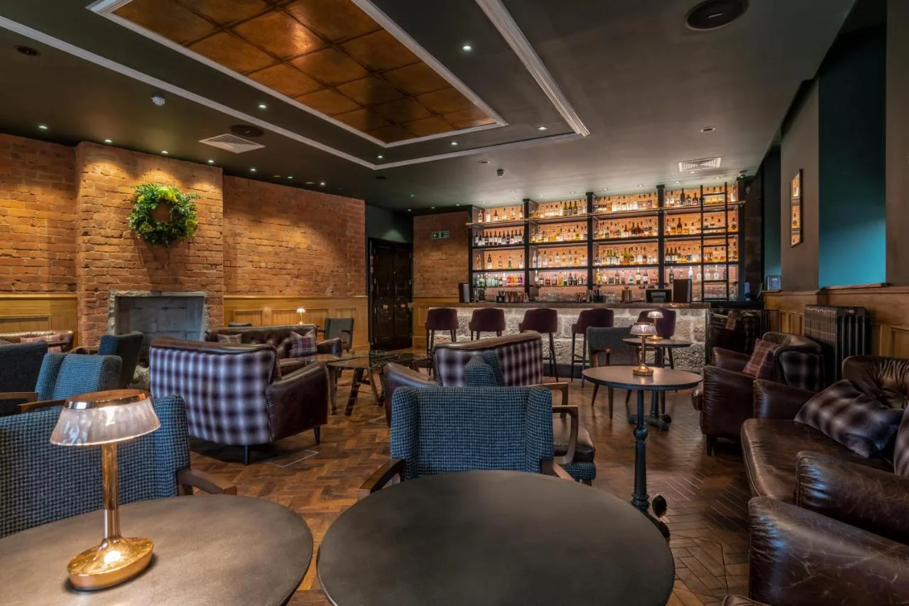 a bar with chairs and tables in a restaurant at Sandman Signature Aberdeen Hotel & Spa in Aberdeen