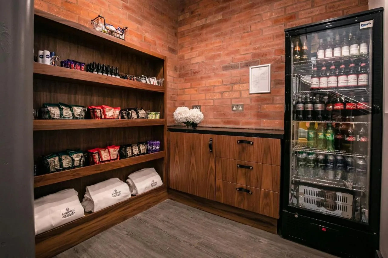 a room with a refrigerator and shelves with drinks at Sandman Signature Aberdeen Hotel & Spa in Aberdeen