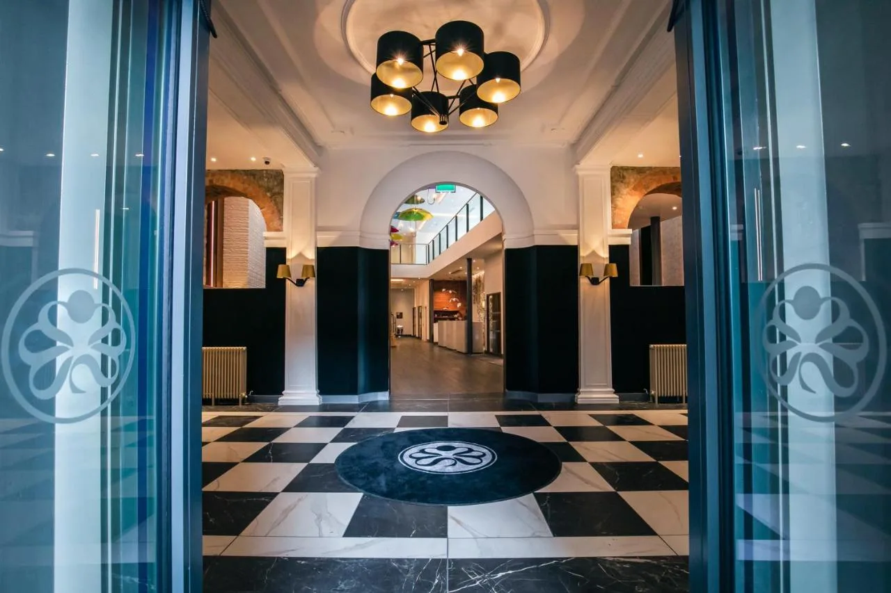 a lobby with a chequered floor and a chandelier at Sandman Signature Aberdeen Hotel & Spa in Aberdeen